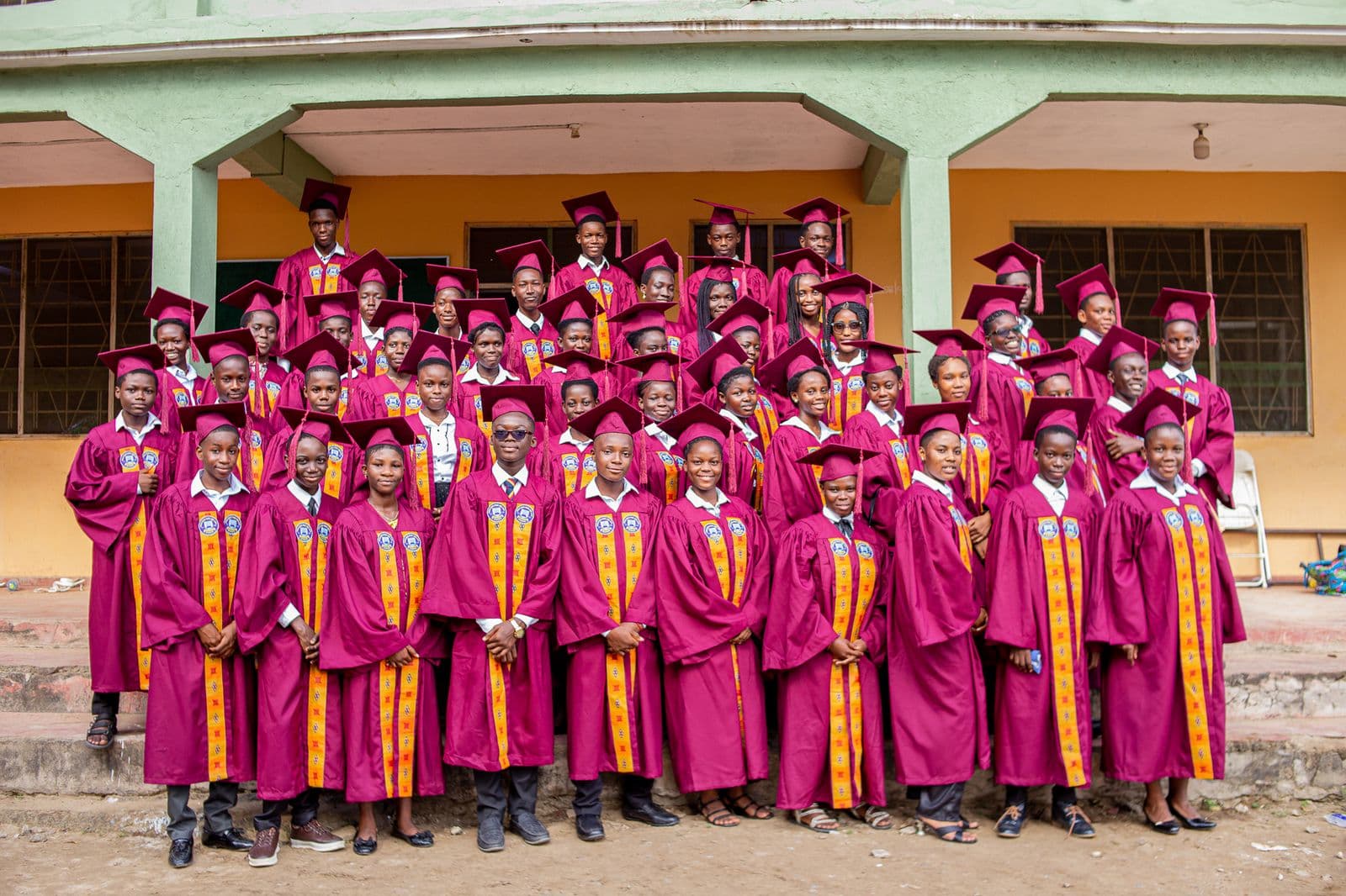 A large group of Black African graduates in caps and gowns celebrating together