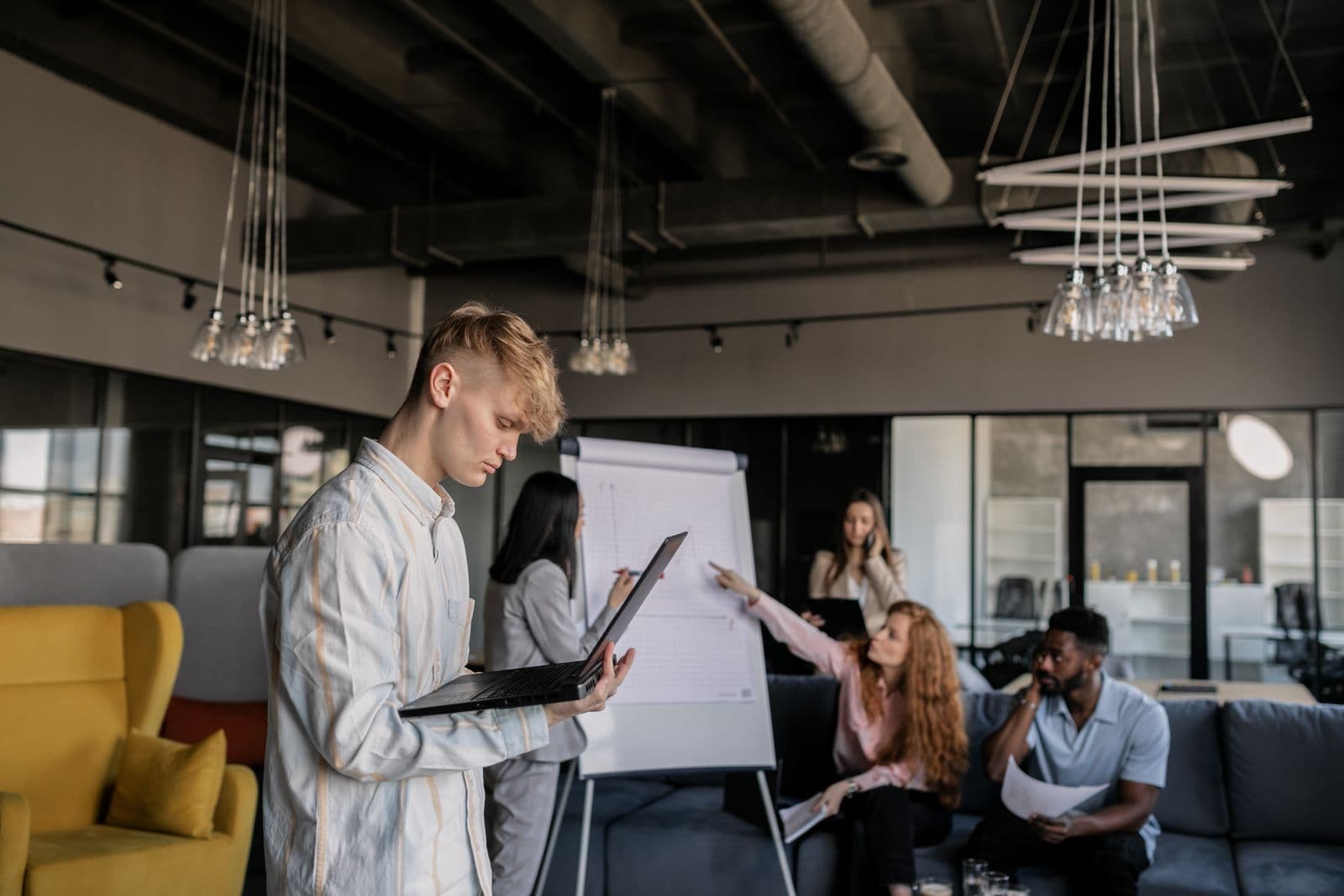 Young people of mixed backgrounds building and working in a modern, industrial-style workspace